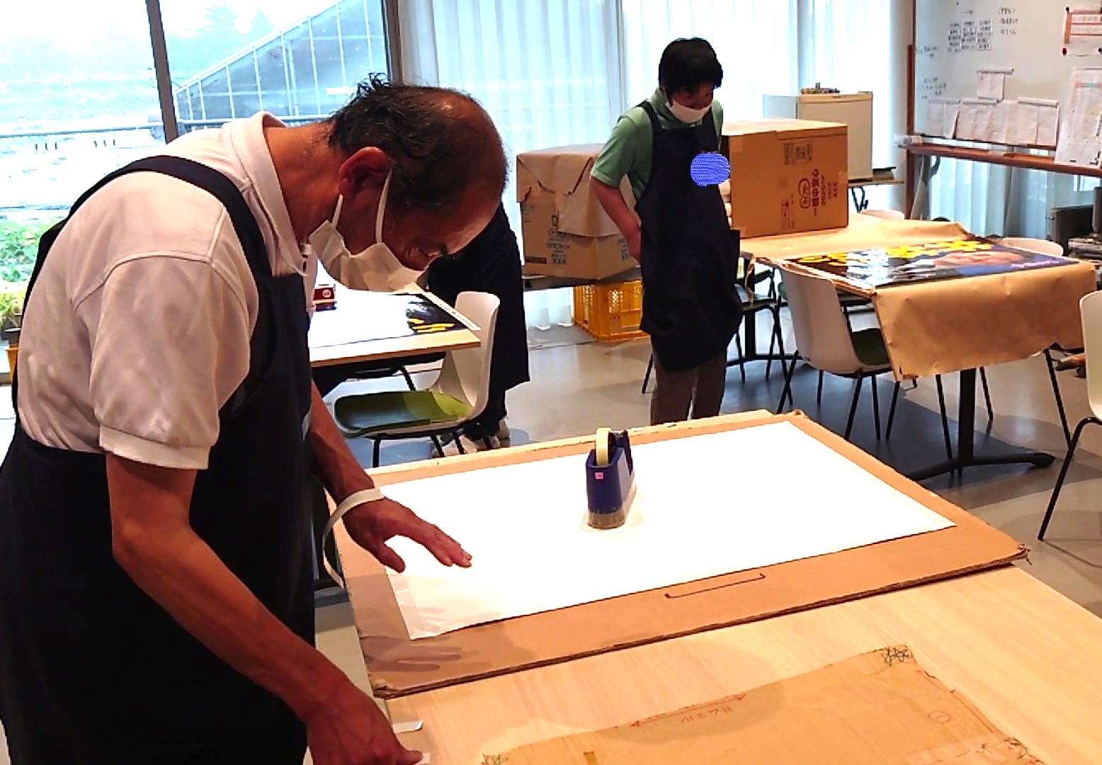 ポスター作業　テープ貼り