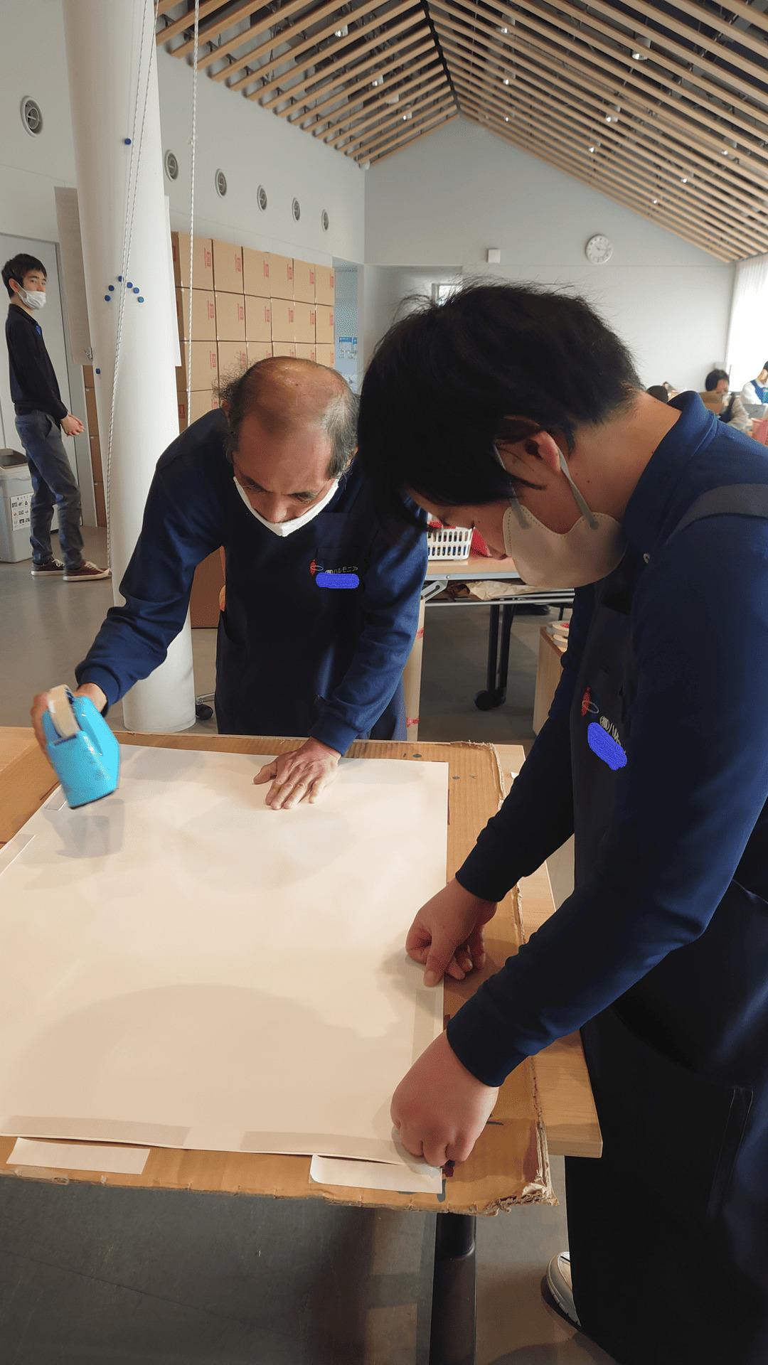 ポスター作業　テープ貼り