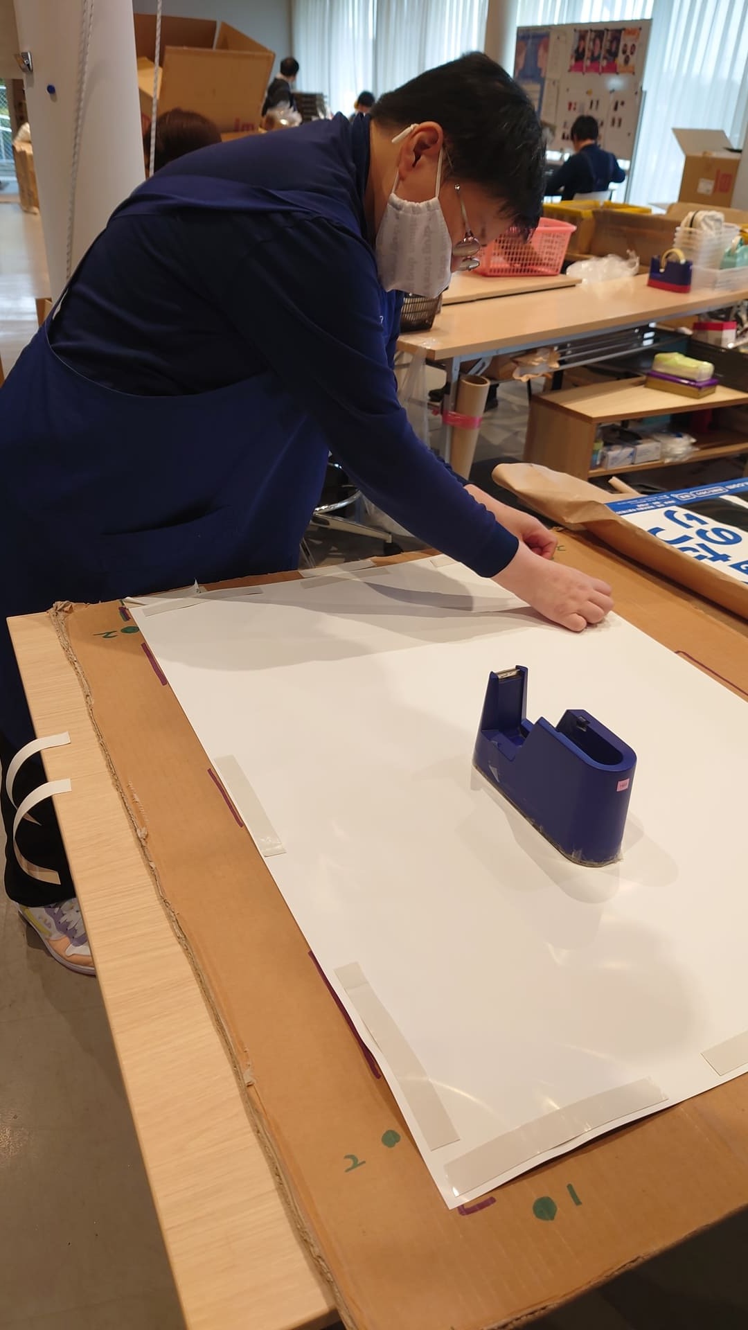 ポスター作業　裏面シール貼り